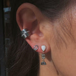 Image of Marrow Fine earrings on ear. The ear stack has a white gold small circle stud, a white gold ear cuff with a thin row of diamonds, and an opal dangle earring.  