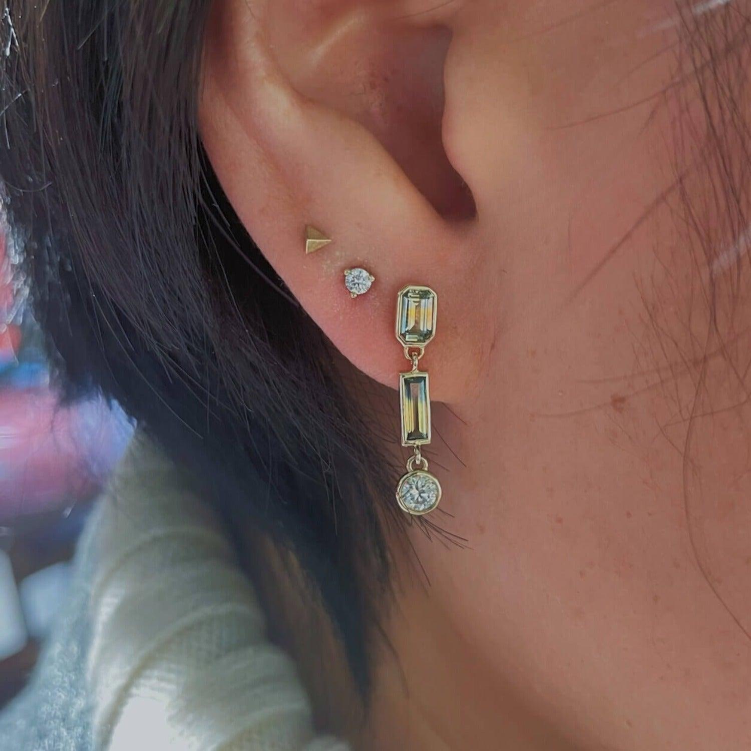 Image of dangle earrings on ear. 