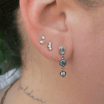 Image if ear with Marrow Fine white diamond stud earrings and Sapphire and Diamond Bezel Set Dangle Earrings on. There are three earrings on this single ear/