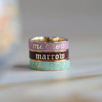 Flat lay of 3 Marrow Fine Custom Enamel Bands stacked together, all reading 'Marrow' in different color ways