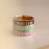 Flat lay of 3 Marrow Fine Custom Enamel Bands stacked together, all reading 'Marrow' in different color ways