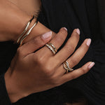 Close up of woman resting hand on her arm, featuring multiple Marrow Fine rings styled