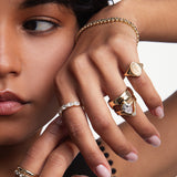 close up of woman resting hand against her face featuring multiple styled Marrow Fine rings