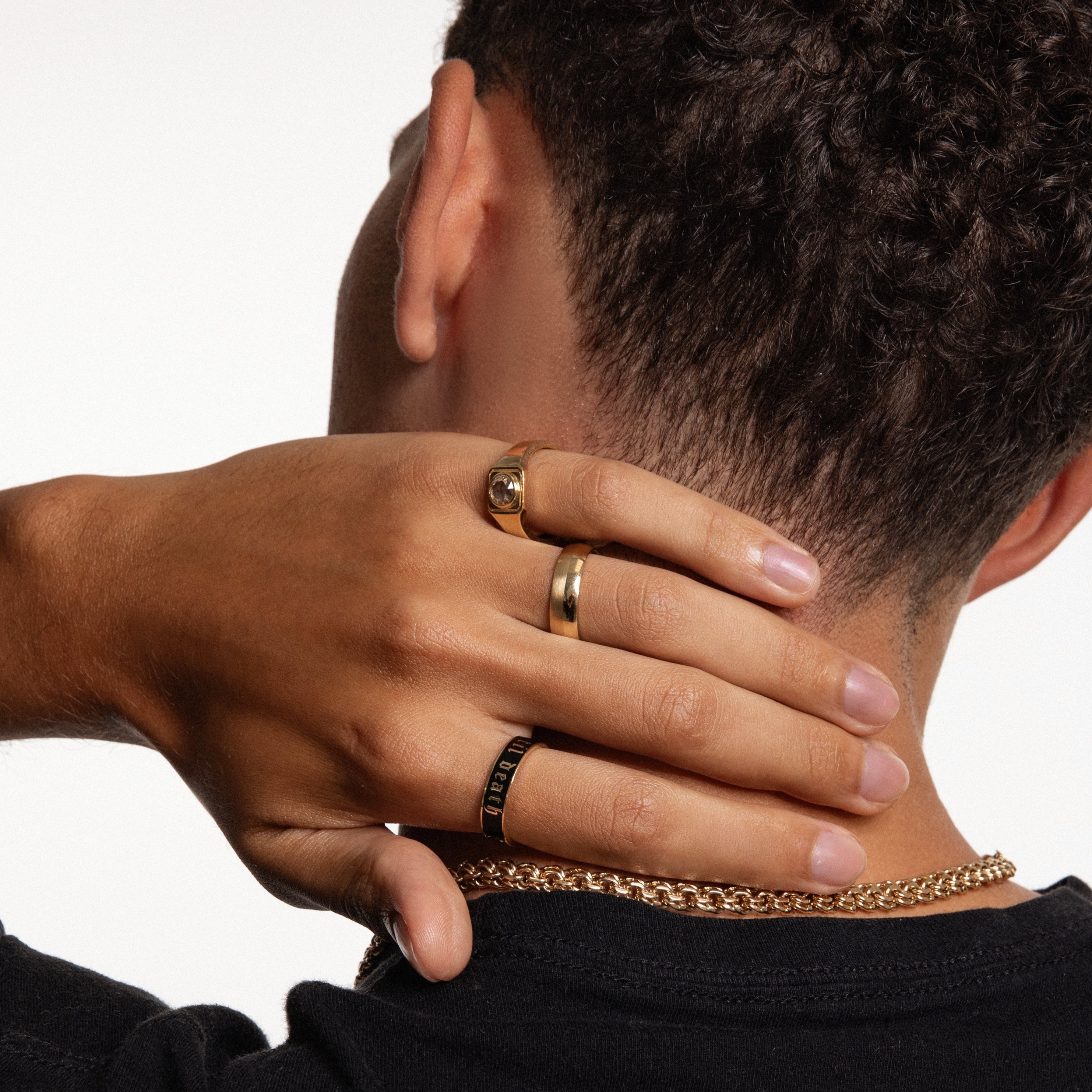 Close up of man's hand against back of his neck featuring multiple Marrow Fine men's bands