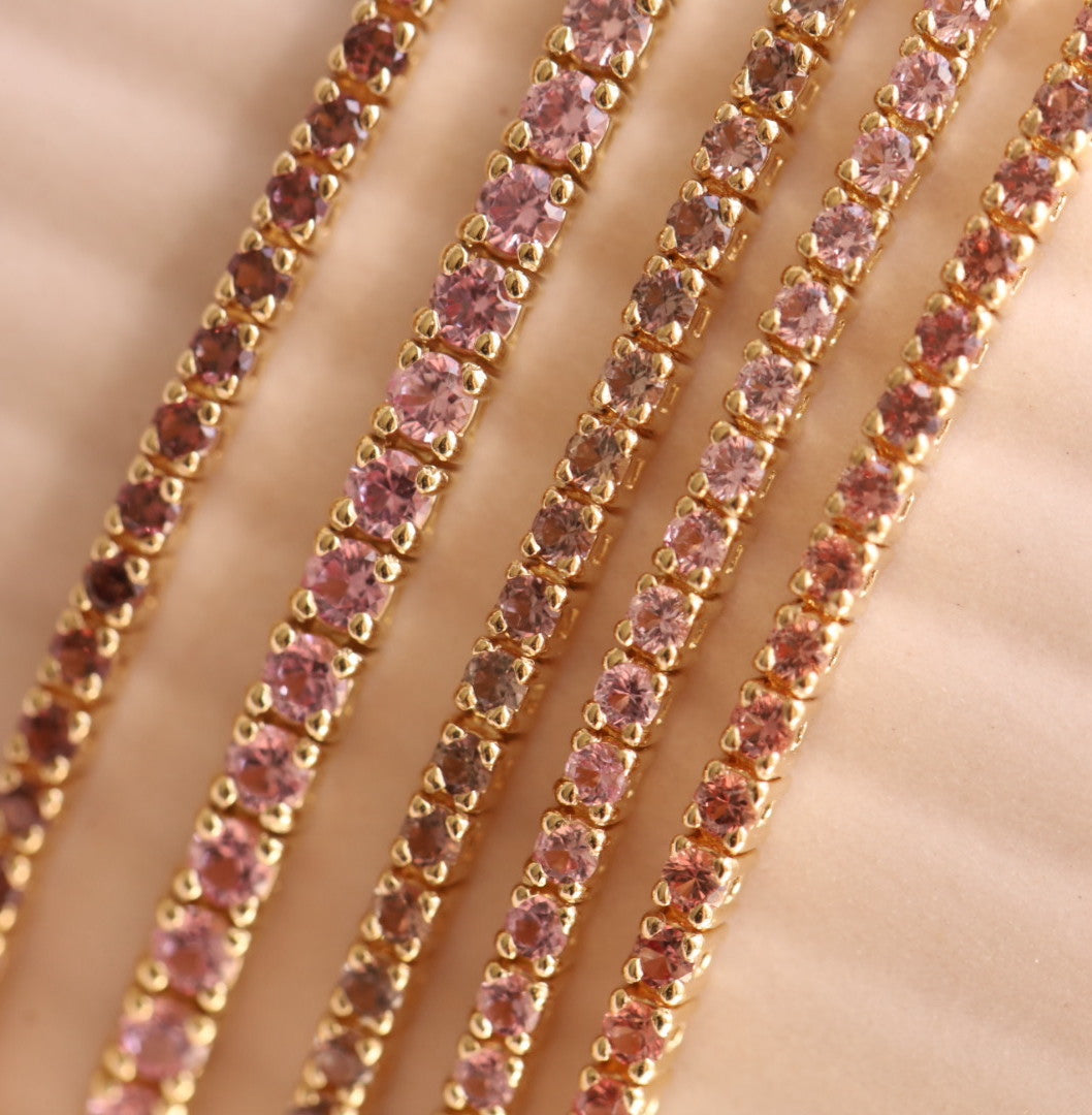 Flat lay of one-of-a-kind tennis bracelets - pink, persimmon and lilac