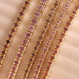 Flat lay of one-of-a-kind tennis bracelets - pink, persimmon and lilac