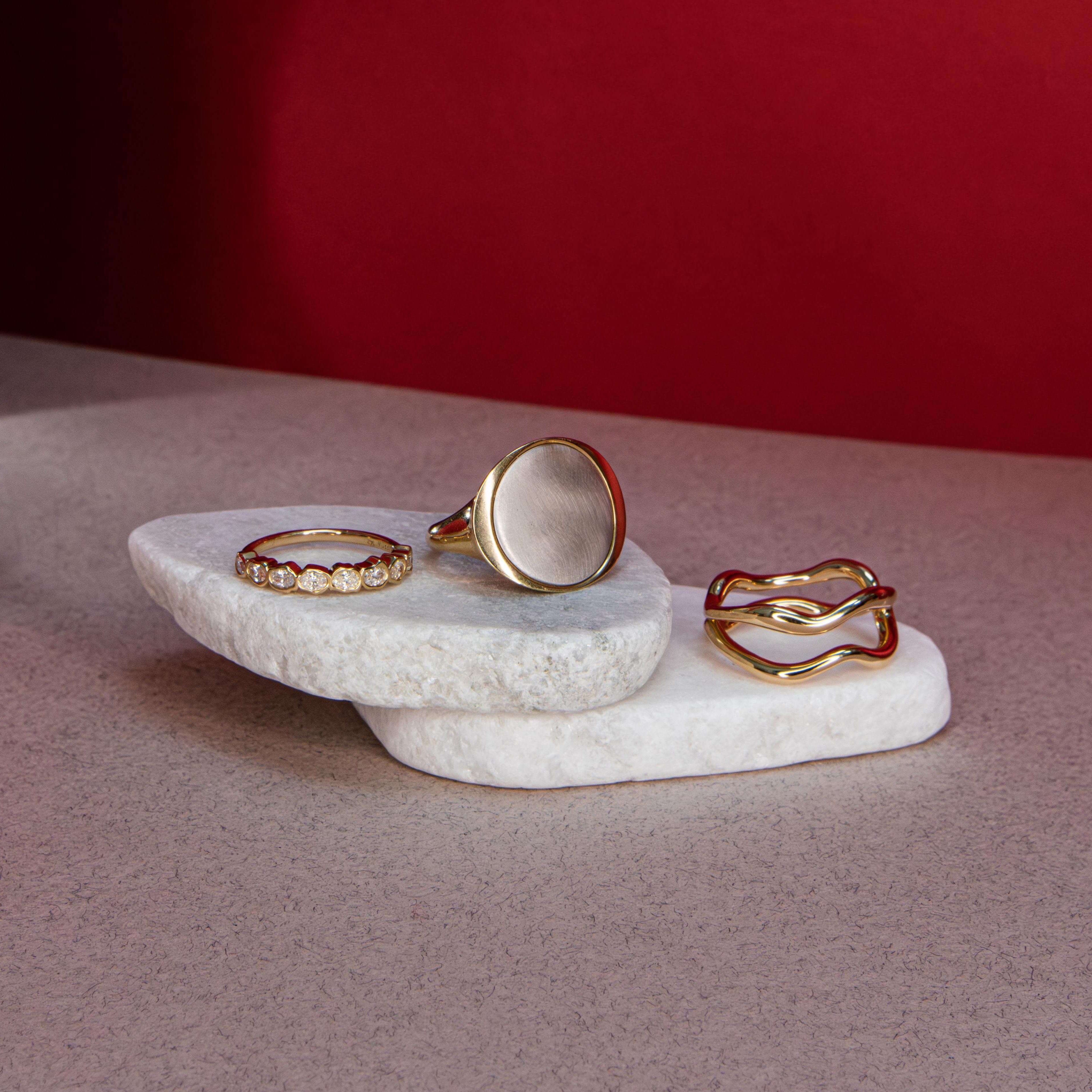 Flat lay of Medium Kelly Statement Ring + White Diamond Abstract Bezel Band + Freeform Ring