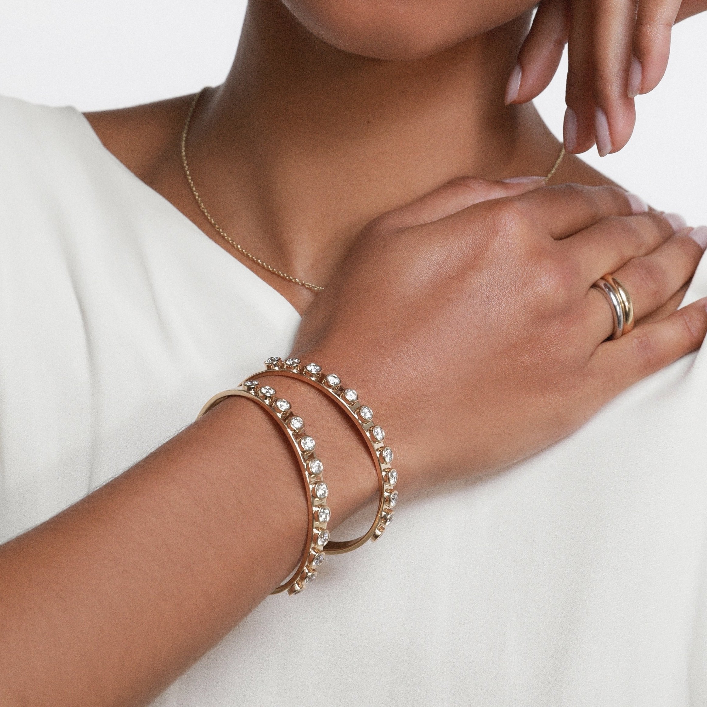 close up of woman's hand wearing two Marrow Fine Little White Diamond Cuffs