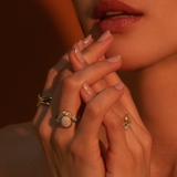 Close up of woman with hands near her face, wearing the Mary Opal Abstract Bezel Ring