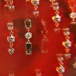 Image of Sapphire and Diamond Bezel Set Dangle Earrings on a deep red background. 