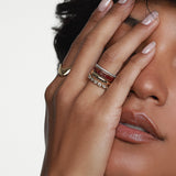 Close up of woman's hand resting on her face, featuring multiple Marrow Fine Rings