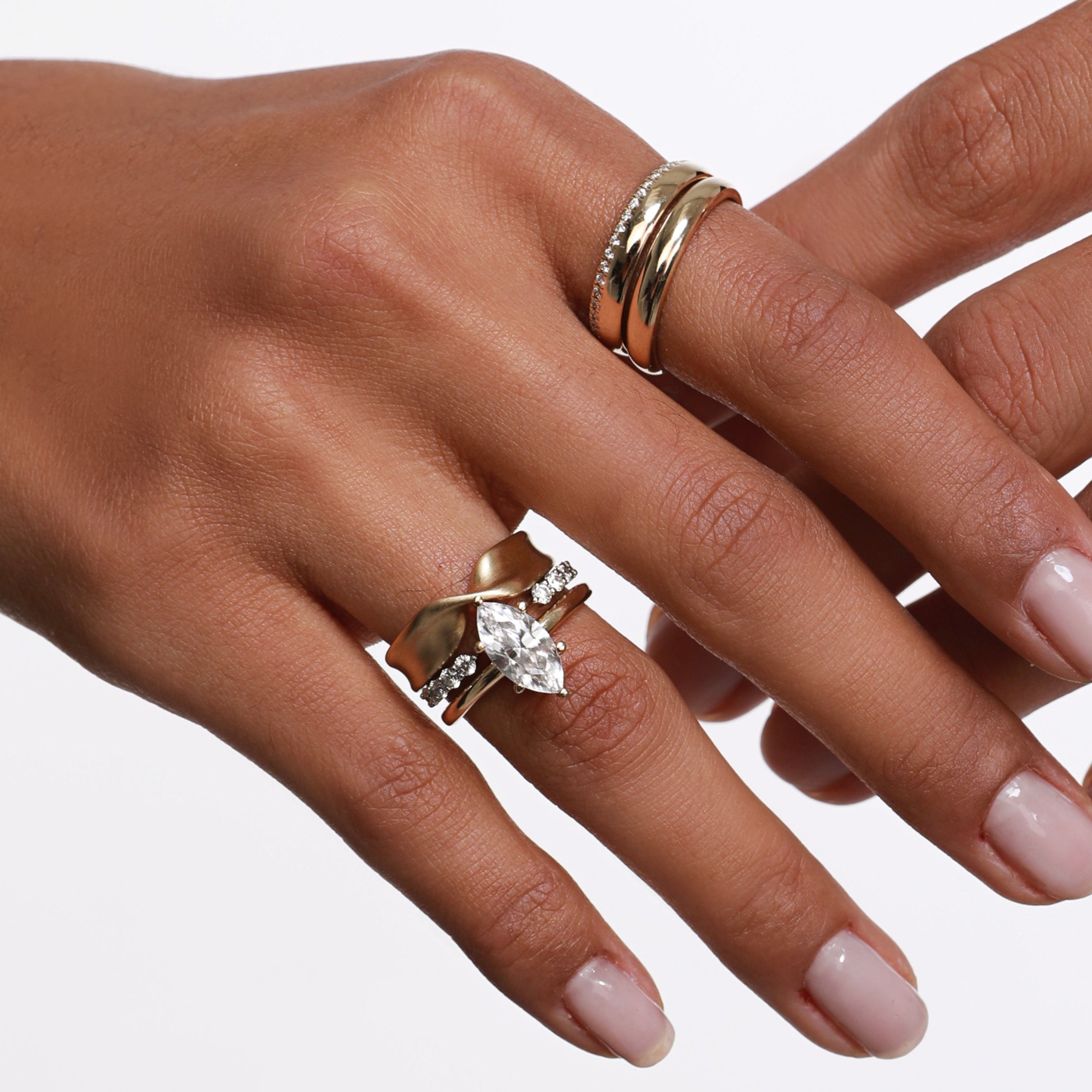 Close up of woman's hand wearing multiple Marrow Fine rings