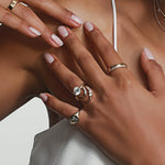 close up of woman's hands resting against her décolletage featuring multiple Marrow Fine rings styled